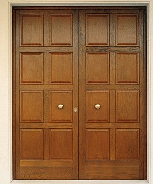 Portone a due ante simmetriche con bugne in Okumè impiallaciate.